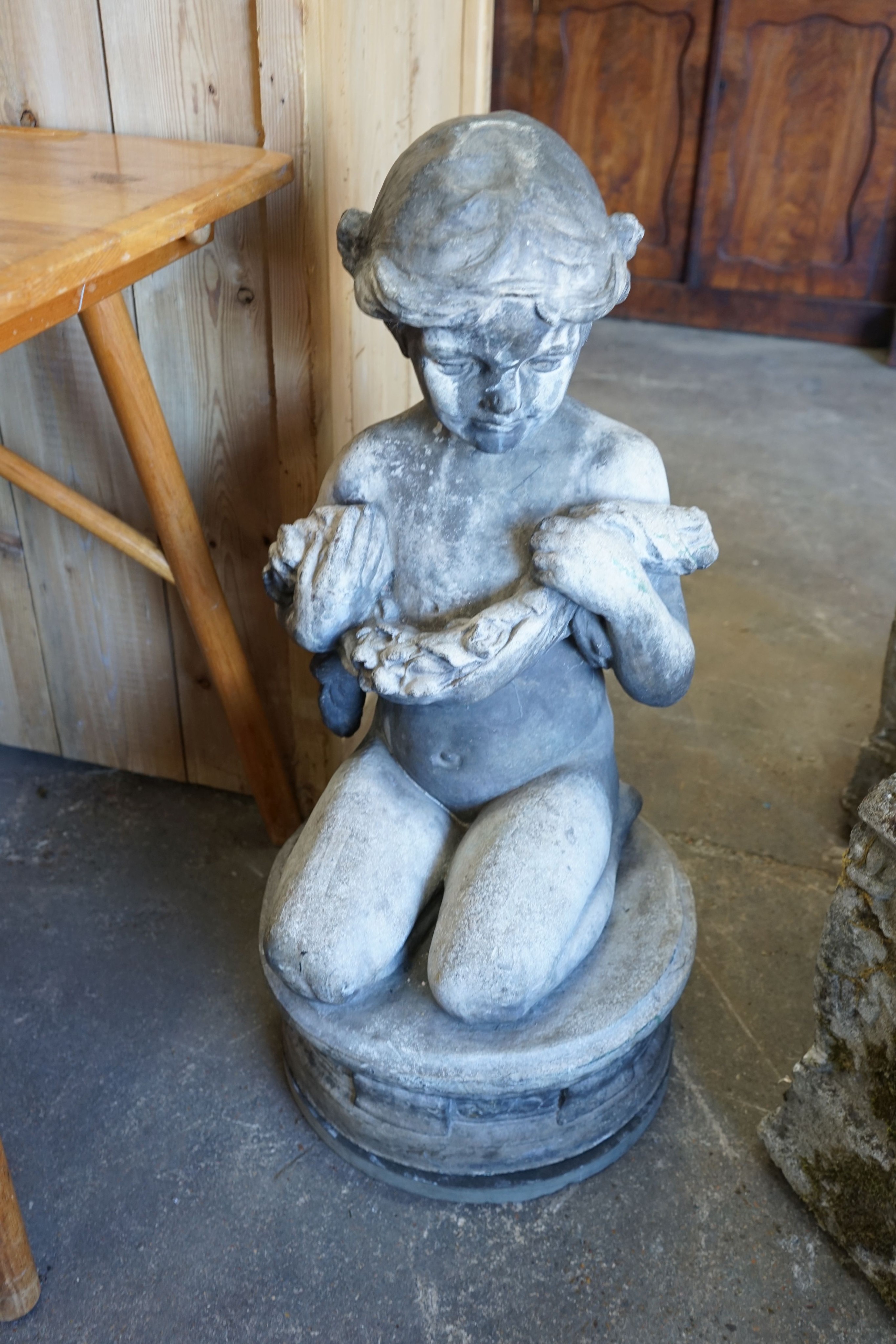 A lead garden ornament of a kneeling child with floral garland, signed Ruby Levick Bailey, 1909, height 74cm